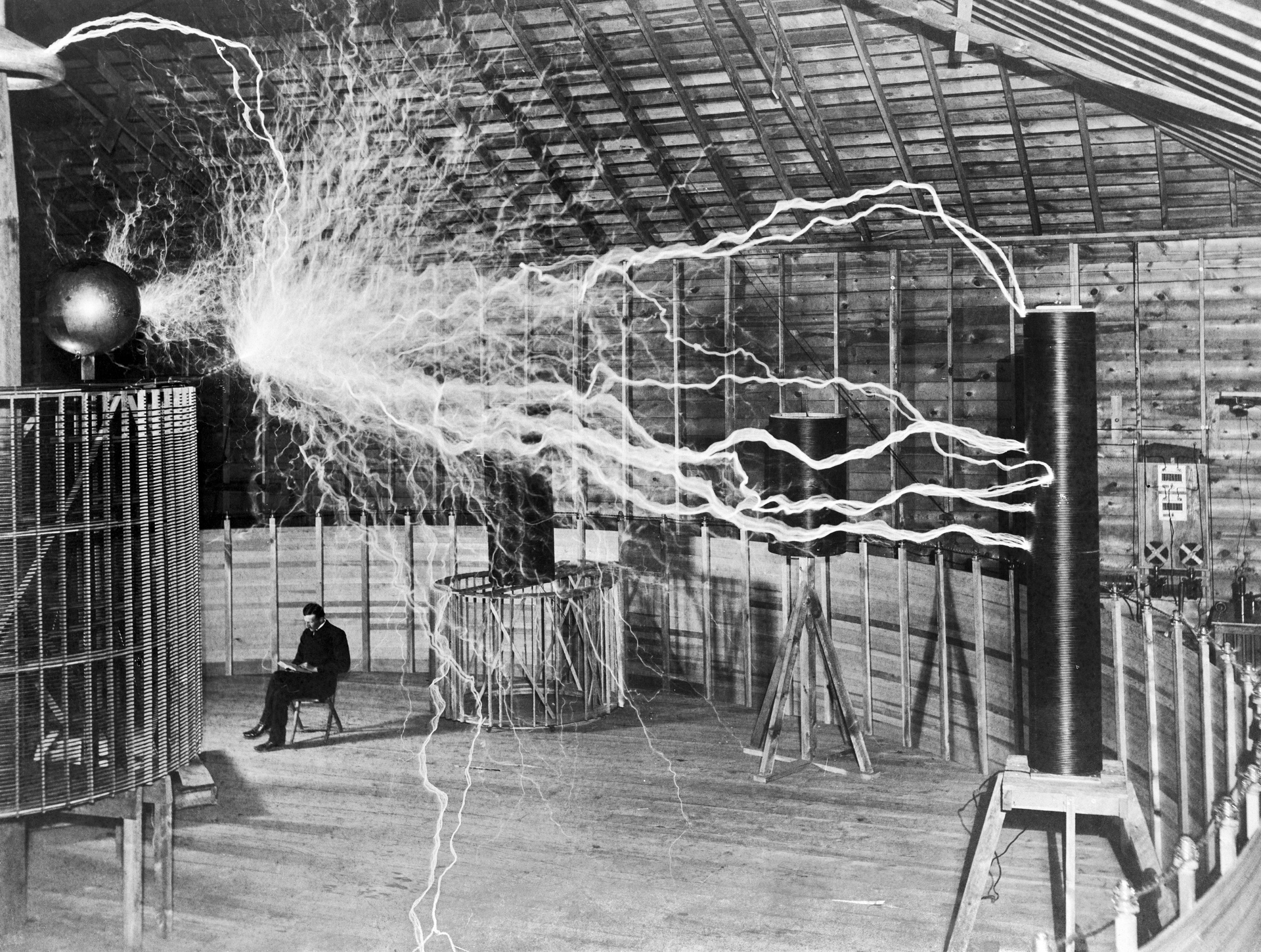 Nikola Tesla, with his equipment for producing high-frequency alternating currents.